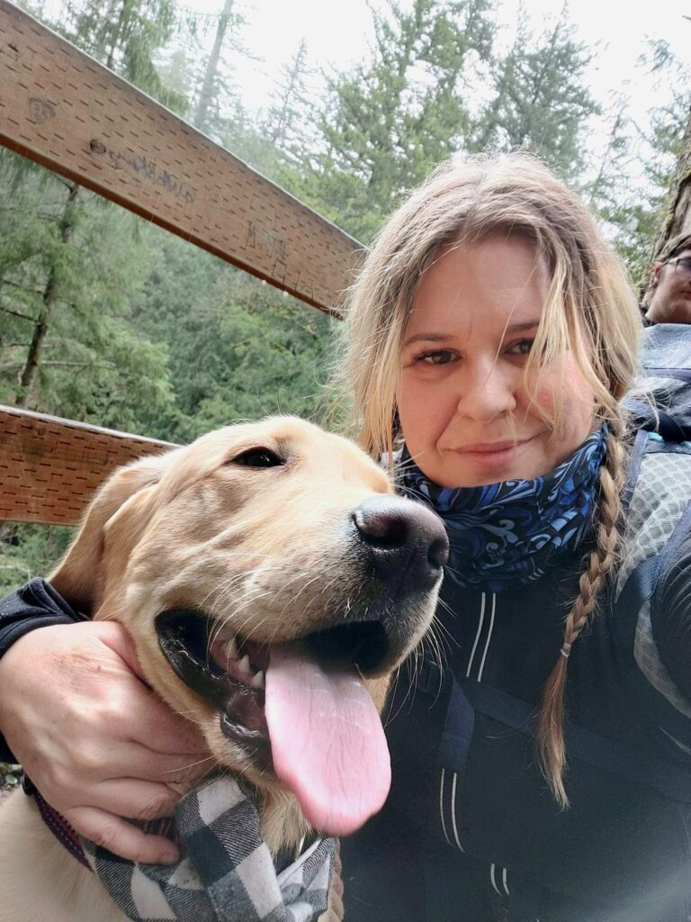 woman with yellow lab on hiking trail during a rest break